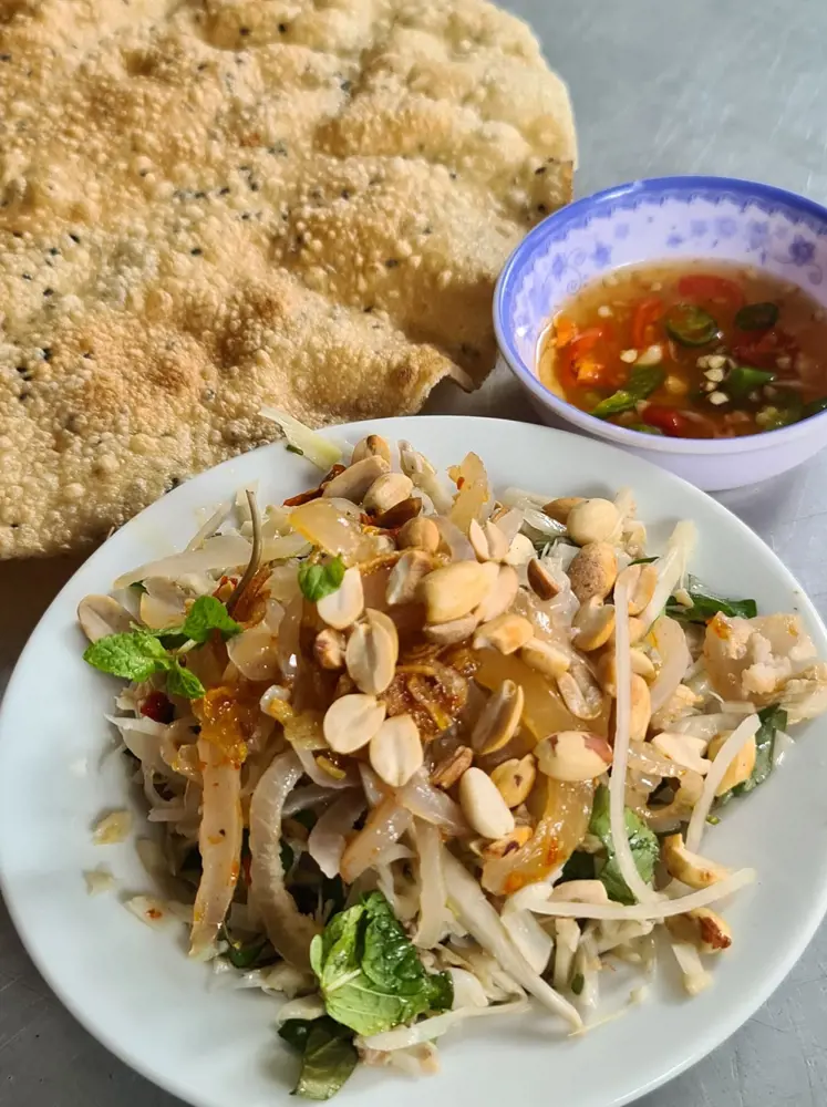 Dĩa mít trộn Đà Nẵng phủ đậu phộng và rau thơm, ăn kèm bánh tráng mè nướng và nước mắm ớt