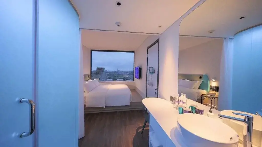 Không gian phòng nghỉ hiện đại tại Tru by Hilton Da Nang City Centre với giường đôi cạnh cửa sổ ngắm toàn cảnh thành phố – Phòng theo hướng compact nhưng tối ưu công năng