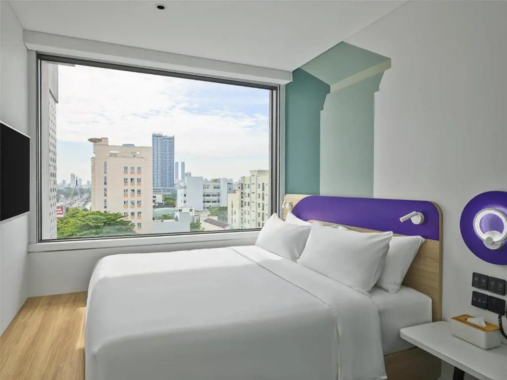Phòng nghỉ giường cỡ King hiện đại với cửa sổ kính lớn nhìn ra thành phố tại Tru by Hilton Da Nang City Centre – Lựa chọn phòng King và Twin