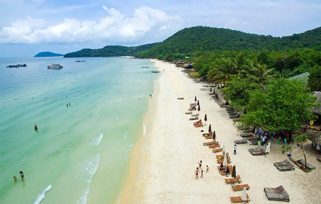 Toàn cảnh Bãi Sao ở Phú Quốc nhìn từ trên cao với bờ cát trắng mịn, nước biển xanh ngọc bích và hàng ghế gỗ nghỉ dưỡng dọc bờ biển. – Bãi Sao: điểm dừng nhanh cho người thích biển và chụp ảnh