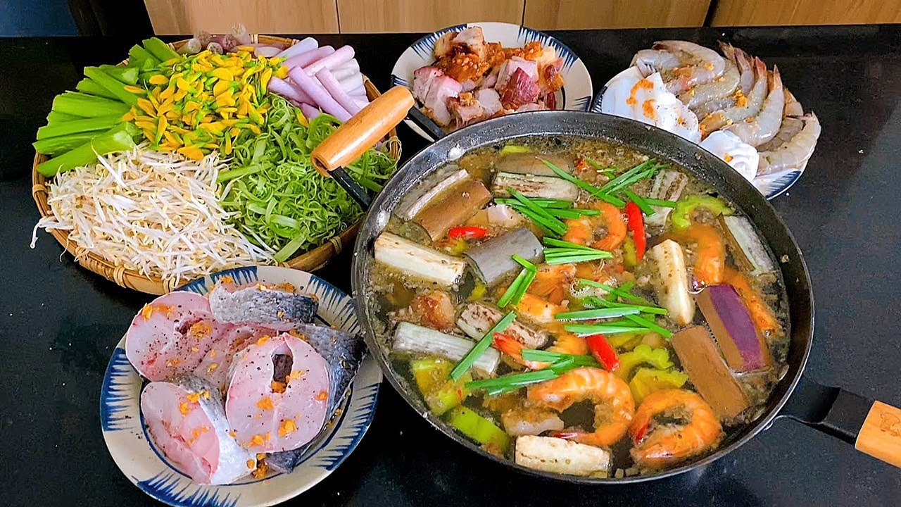 Nồi lẩu mắm miền Tây Nam Bộ với tôm, cá, cà tím và các loại rau ăn kèm như bông điên điển, rau muống chẻ, giá đỗ.