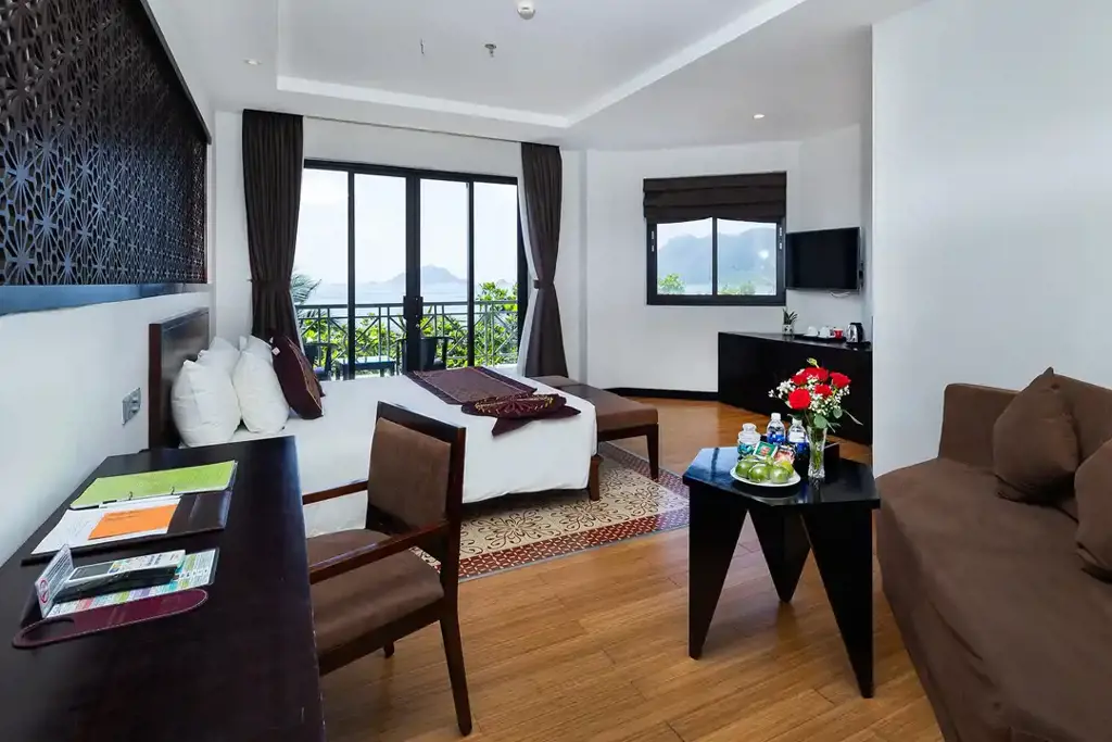 Phòng nghỉ dưỡng hiện đại tại Côn Đảo Resort với giường ngủ lớn, sofa và ban công hướng biển đón ánh sáng tự nhiên.